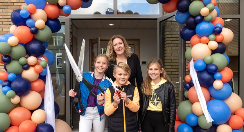 Balonnenboog met juf en drie kinderen voor opening gebouw Vroondaal